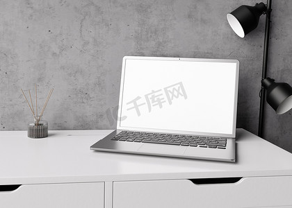 在家或办公室的白色桌子上有空白白色屏幕的笔记本电脑。