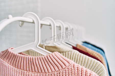 衣衣服摄影照片_衣架上挂着五彩女式羊毛衫。