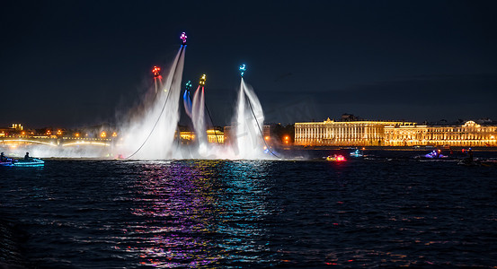 水上活动摄影照片_许多飞行板爱好者和穿着鲜艳的喷气式滑雪者晚上在圣彼得堡市中心的一个假期表演他们的表演，水上活动