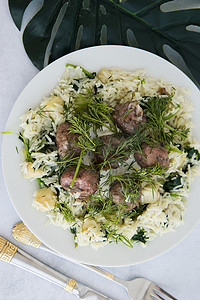 瑞典肉丸配莳萝，上面撒上芹菜和菠菜米饭。