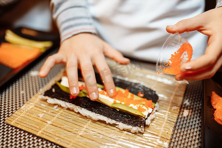 寿司师傅摄影照片_孩子们在大师班上制作寿司。