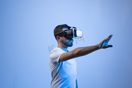 留着胡子的年轻男子戴着 VR 耳机观看具有 AR 体验的 3D 虚拟视频。