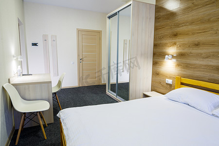 酒店宽敞明亮的客房配有床、电视和衣柜。