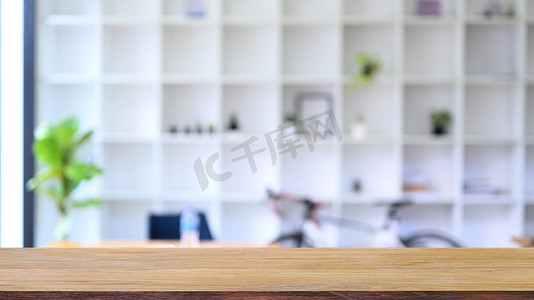 房屋书架摄影照片_木桌与模糊的书架在背景中。