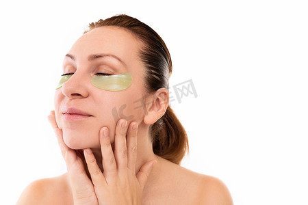 中年妇女洗完澡后触摸脸部皮肤，用手指轻轻抚摸闭上眼睛