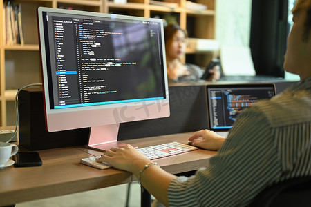 男性软件开发人员在电脑屏幕上检查编程代码错误的裁剪视图