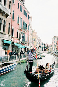 新娘和新郎乘坐贡多拉前往威尼斯运河桥
