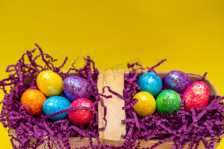 黄色背景下为假期准备的篮子和彩蛋的复活节组合物