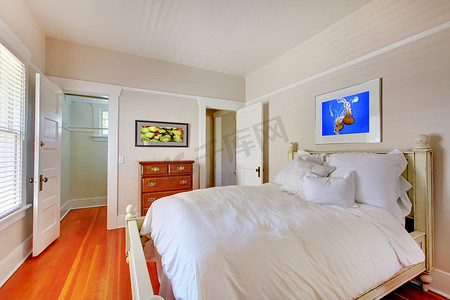 卧室配有白色床和樱桃硬木地板。