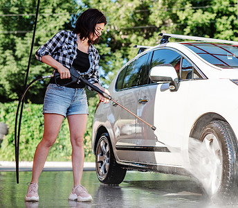 洗车汽车摄影照片_自助洗车的女人