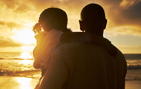 慈爱剪影摄影照片_一位慈爱的父亲和女儿观看日落景色的剪影。