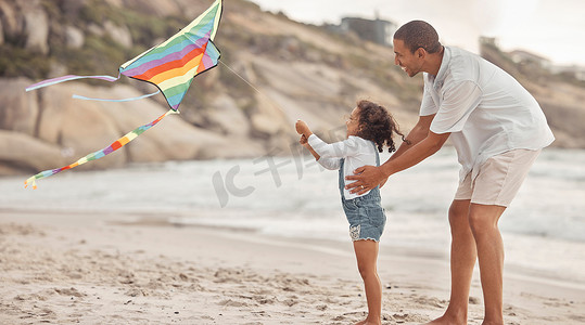 父亲带着支持、爱和关怀教孩子在沙滩风中放风筝。