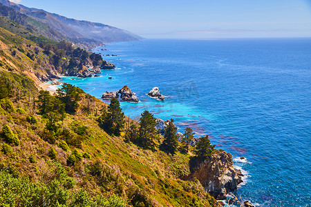 西海岸充满活力的蓝色海洋，有山脉和岩石