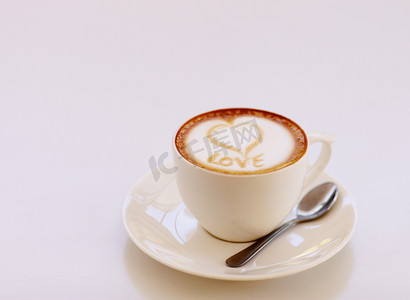 咖啡爱好者摄影照片_充满爱意的制作...高角度拍摄的一杯精心准备的卡布奇诺咖啡坐在咖啡桌上。