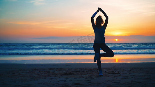 树剪影剪影摄影照片_剪影女人练习瑜伽树姿势冥想与暑假海滩幸福和放松。