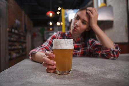 悲伤的女人摄影照片_悲伤的女人喝啤酒