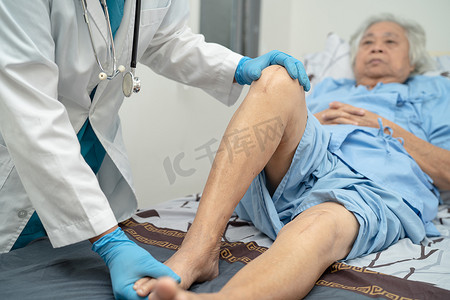 注射治疗摄影照片_亚洲医生物理治疗师在骨科医疗诊所护士医院检查、按摩和治疗老年患者的膝盖和腿部。