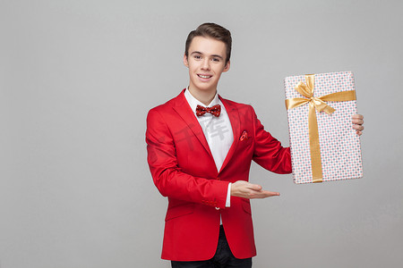 端午节礼摄影照片_开朗优雅英俊的绅士肖像指着大包装的礼物盒。