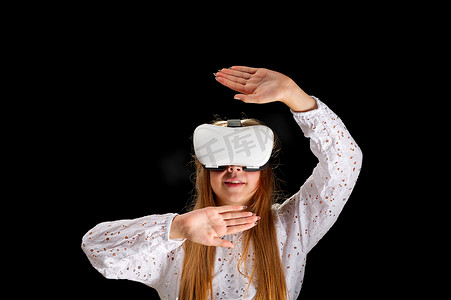 虚拟现实现实摄影照片_身穿白衬衫和牛仔裤、戴着虚拟头盔的年轻女子。