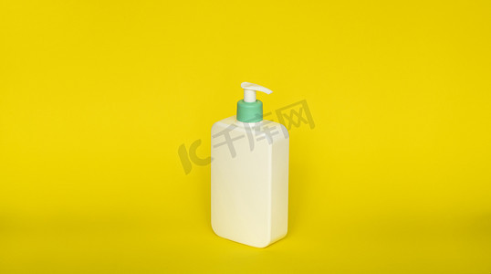饮水机摄影照片_黄色背景上的白色无品牌饮水机瓶。