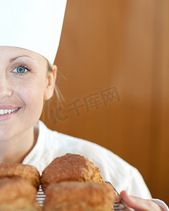 一位微笑的女厨师烘烤烤饼的特写