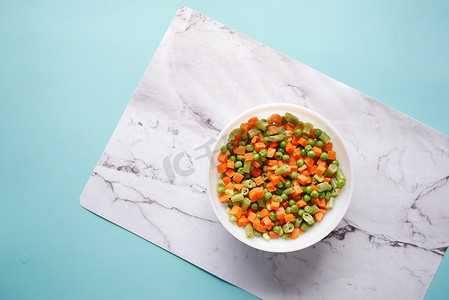 花砖平铺底纹摄影照片_碗里玉米、胡萝卜和豆子的顶视图，