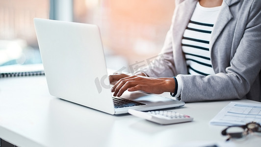 女会计师在办公室的笔记本电脑上打字，或坐在办公桌前在互联网上进行研究。