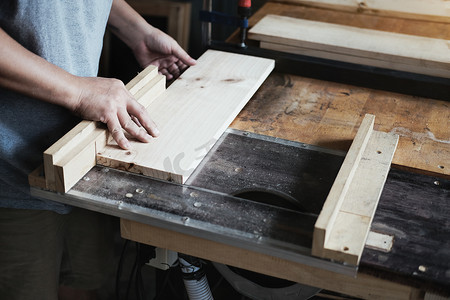木工从业者使用锯片切割木块，为客户组装和建造木桌。