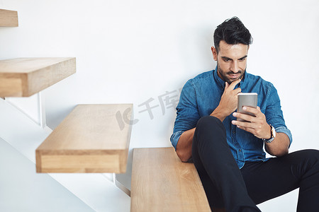 男性坐在台阶上打电话发短信，在线浏览社交媒体。