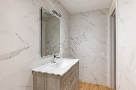 简单而现代的浴室配有大理石瓷砖、水槽和镜子