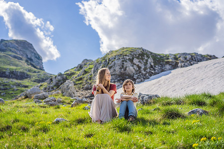 黑山美丽的杜米托尔国家公园的山湖景观中的游客母子家庭，有湖冰川和反射山