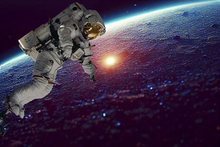 外太空地球摄影照片_宇航员太空人在外太空空间站工作时进行太空行走。