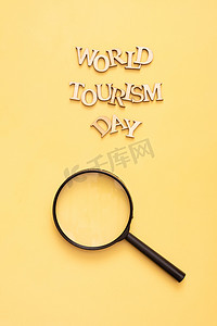 木摄影照片_黄色背景上的木字和放大镜的世界旅游日文字