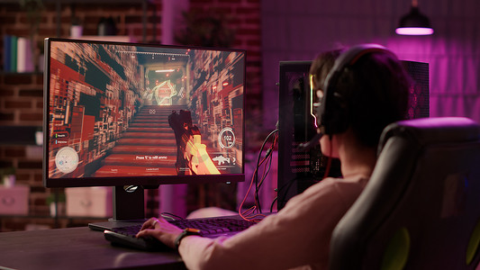 使用电脑游戏设置放松玩多人在线动作视频游戏的玩家女孩的肩部视图