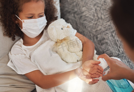 在covid期间用消毒剂清洁双手，有爱心的母亲为生病的孩子表现出良好的卫生习惯。
