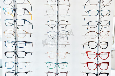 眼镜、验光师和货架，在零售和眼部护理行业的橱窗里摆放着新的、时尚的、色彩缤纷的眼镜。