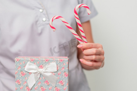 身穿医疗制服的女性，配有礼品盒和圣诞糖果