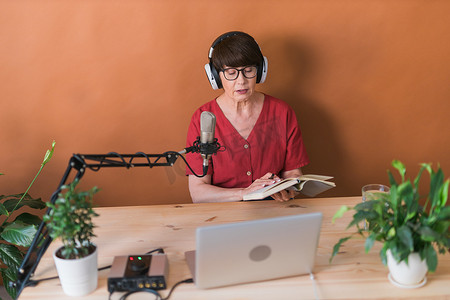 中年女电台主持人对着麦克风讲话并阅读新闻 — 电台广播在线概念