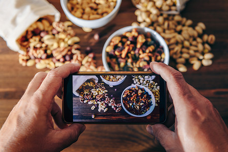 美食博主用手机拍摄各种坚果的照片