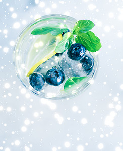 冬季假期鸡尾酒，背景是冰和发光的雪，圣诞节菜单配方