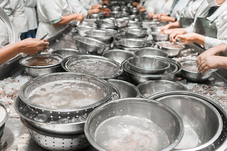 一群拉丁裔工人在一家工厂清洗虾