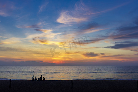 海边海滩日落时一群人的剪影。