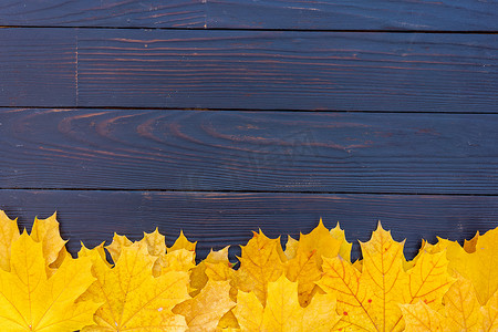边框黄色背景摄影照片_秋叶框架在木质背景顶视图秋季边框黄色和橙色叶子复古木桌复制文本空间。