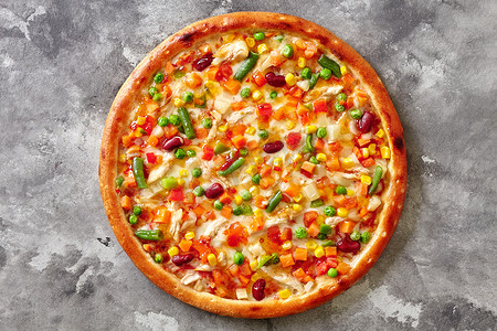彩色披萨配马苏里拉奶酪、真空低温烹调法鸡肉、灰色石头表面的蔬菜混合物