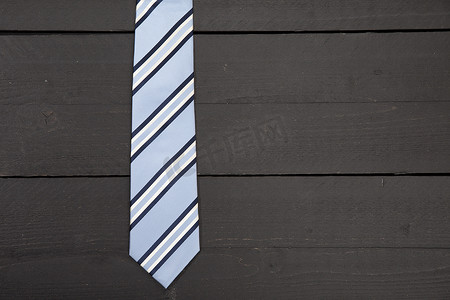 深色木质背景上的条纹商务领带