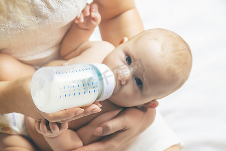 妈妈用奶瓶给宝宝喂奶。