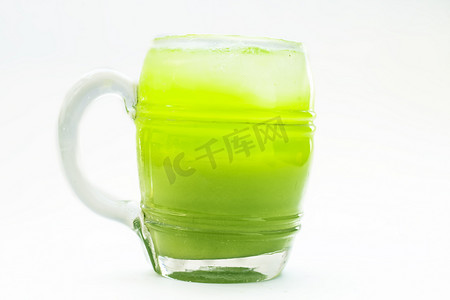 芹菜汁摄影照片_新鲜欧芹汁或香菜汁在透明玻璃中隔离在白色与新鲜欧芹叶。