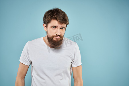 穿白色T恤的男人情绪面部表情裁剪视图工作室蓝色背景生活方式