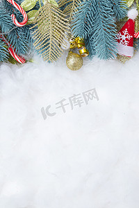 金色框架图摄影照片_由冷杉树枝和圣诞装饰品制成的框架平铺在雪背景上，具有复制空间垂直格式