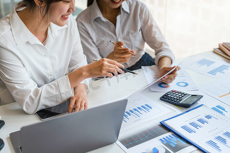 谈判、分析、讨论：亚洲女性经济学家和营销人员指着财务数据表来规划投资，以防止公司风险和损失